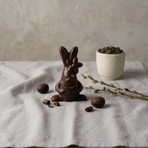 Figurine en chocolat de Pâques en forme de lapine avec une fleur sur la tête, fabrication artisanale.