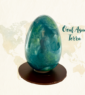 Œuf de Pâques en chocolat Aqua Terra au glaçage bleu et vert marbré représentant la Terre, posé sur un socle en chocolat