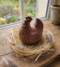 Moulage en chocolat Poule Dindon sur un nid sur une table en bois