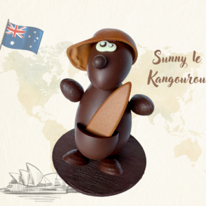 Montage de Pâques artisanal en chocolat représentant Sunny le Kangourou avec une casquette et une planche de surf, sur un socle en chocolat noir.